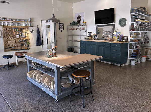 A repurposed set of old kitchen cabinets with a sturdy butcher block countertop is used to store business-related needs and assorted supplies.