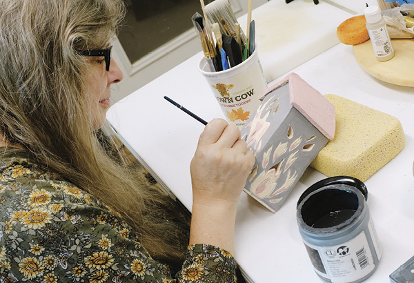 1 Dawn Hintgen uses a sponge as an easel to hold pieces at a good angle while she glazes.