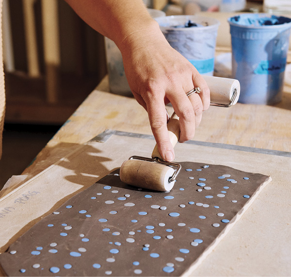4 Creating a pattern using scattered dots of colored clay and a pony roller.