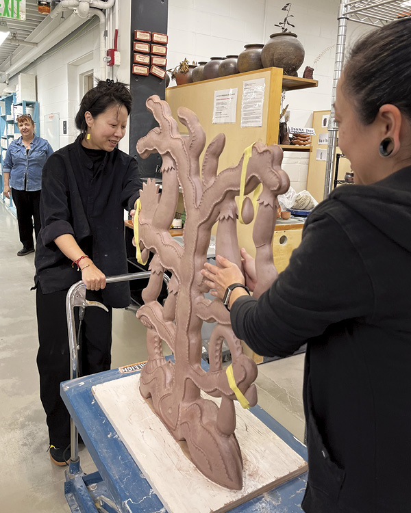 Artist In Residence Chenlu Hou transporting her sculpture to the kiln room, assisted by Dawn Graham and Kathy King. Photo: Margaret Wazuka. Ceramics Program, Office for the Arts at Harvard, Allston, Massachusetts.