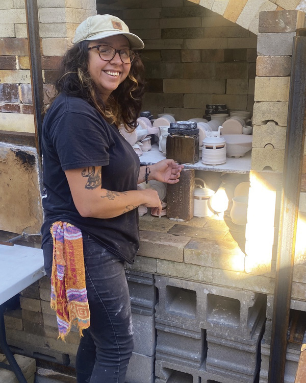 Sinclaire Marie loading a crossdraft wood kiln, 2025. Photos: Jon Stein. Queen City Clay, Norwood, Ohio.