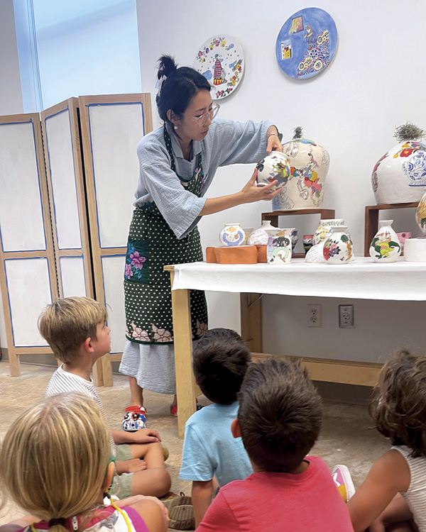 Jihye Han showing her work to a school group in her studio. Photo: Katy Anderson. Houston Center for Contemporary Craft, Houston, Texas.