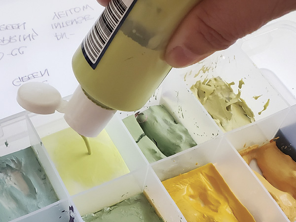 1 Add liquid underglazes to the individual compartments.