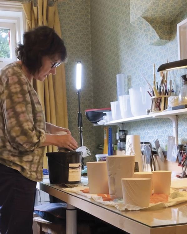 3 Jean White in her work room wet sanding bisqueware. Photo: Heather White.