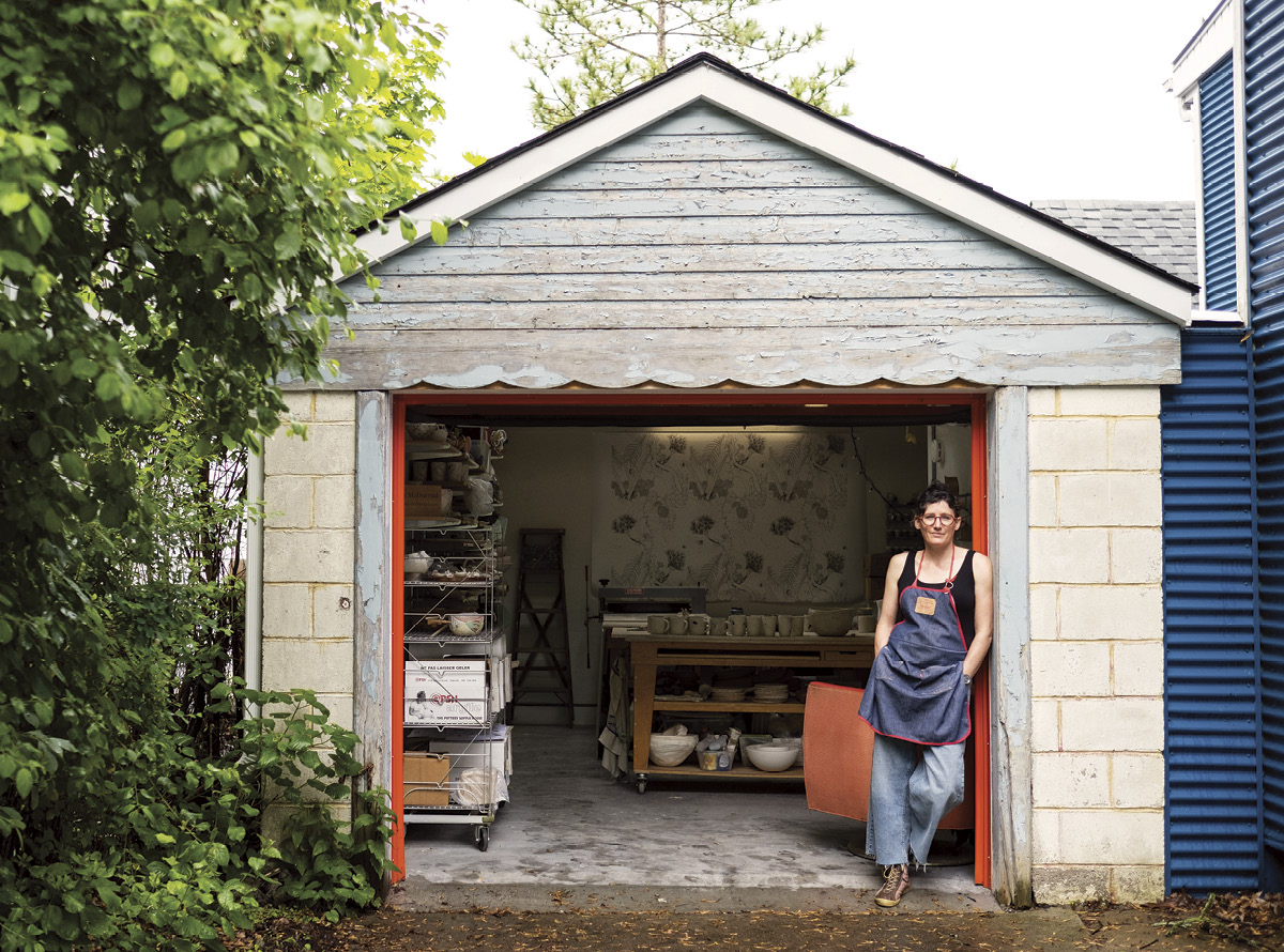 Marney McDiarmid standing outside her studio, a renovated garage next to her house.