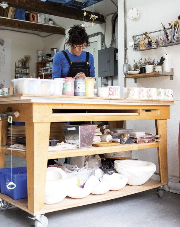 Marney McDiarmid standing at a work table in her studio.