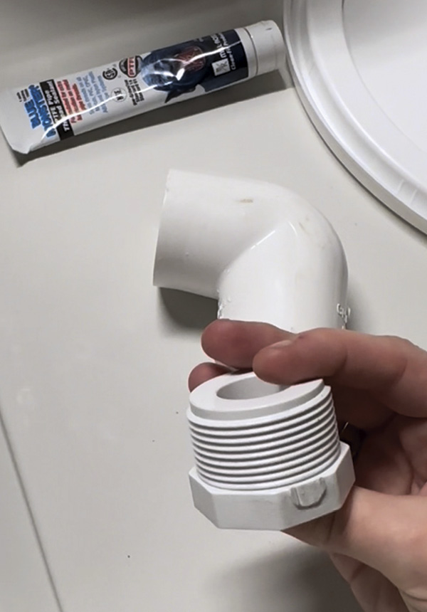 2 Example of the threaded PVC pipe connector that secures the elbow-shaped PVC pipe drain from the interior of the larger bucket.