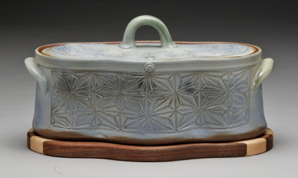 1 Bradley Keys’ Kumiko Blue Skies Casserole Dish with Striped Wood Trivet, 12½ in. (32 cm) in width, hand-carved stoneware, handmade oak, cherry, walnut trivet, 2026.