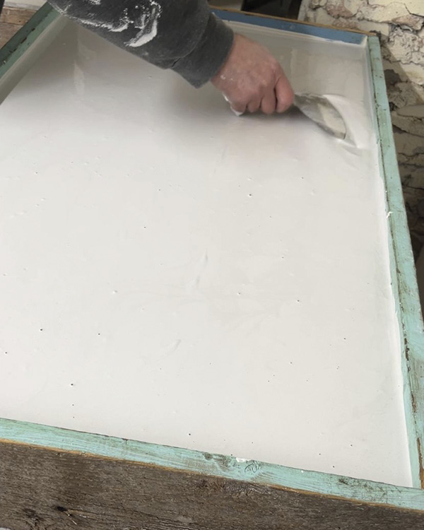 4 Smoothing out the freshly-poured plaster, ensuring there are no air bubbles.