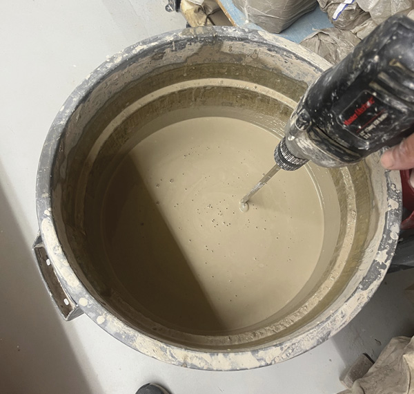 6 Mixing up the bucket of discarded throwing water, preparing to begin the reclaim process.