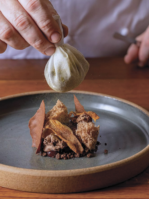 2 Jun Rhee's Plate, red-brown stoneware, dark gray semi-matte glaze, fired in reduction to cone 10 in a gas kiln. Work in use at Sat Bains, a two Michelin star restaurant in Nottingham, UK. Photo: Sat Bains.