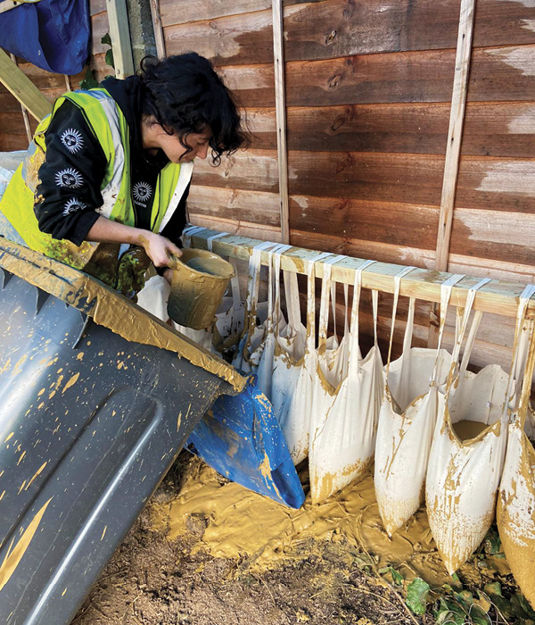 3 A Golden Earth Studio team member pouring the sieved clay slurry into suspended cotton bags to dehydrate. Photos: Gabriel Lau.