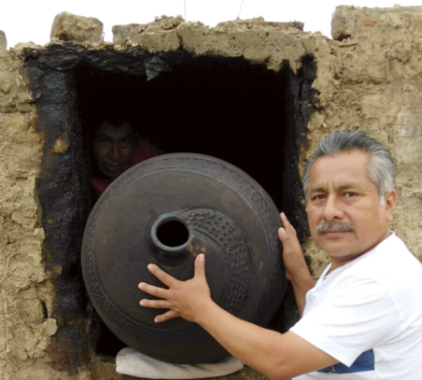 4 Ramírez unloading a smoked vessel from the adobe kiln, for Chulucanas Monumental.