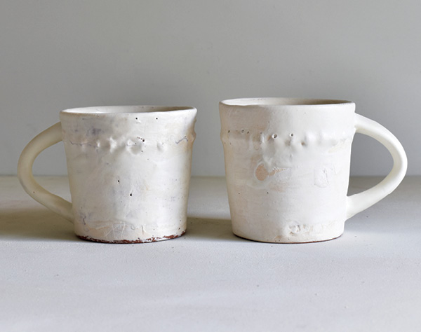 5 Maggie Jaszczak’s mugs, 5 in. (13 cm) in height, wheel-thrown earthenware with brushed 04 white slip, Satin Base Glaze, fired to cone 04 in an electric kiln.