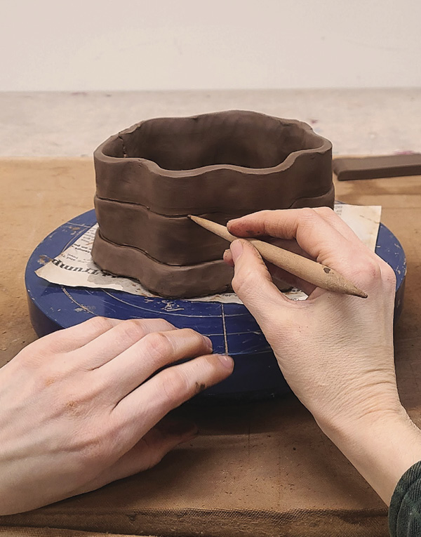 8 Once the first strip is attached, use a wooden modeling tool to blend the strip into the base slab.