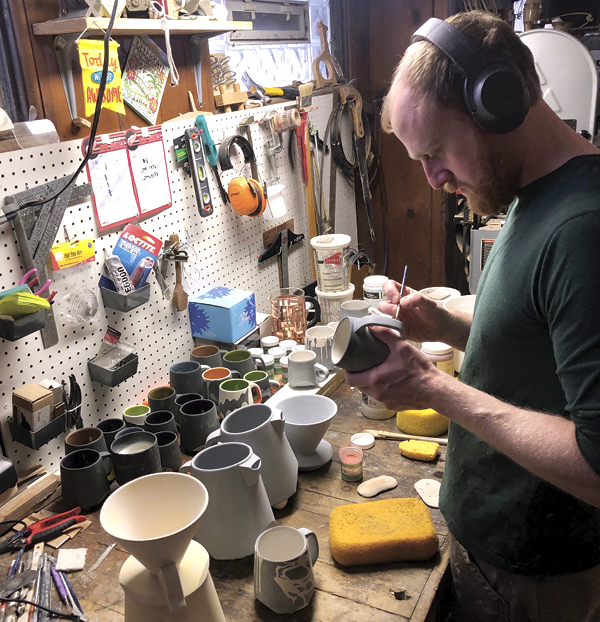 2 Alec Smith adds underglaze details to his work in the ceramics studio located in the basement of the Glastonbury Collective.