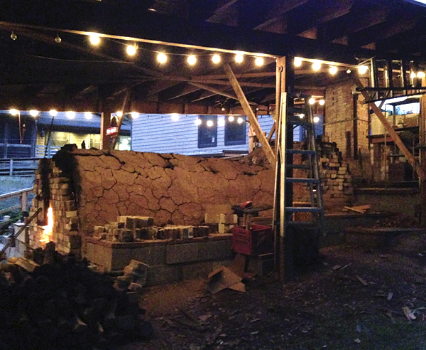 3 Fire peeks out the front stoke door on Justin Rothshank’s wood kiln.
