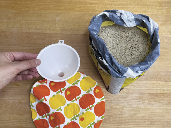 3 Fill the bag with a generous amount of sand using a funnel. Don’t fill it to the brim because this will make it difficult to close the opening.