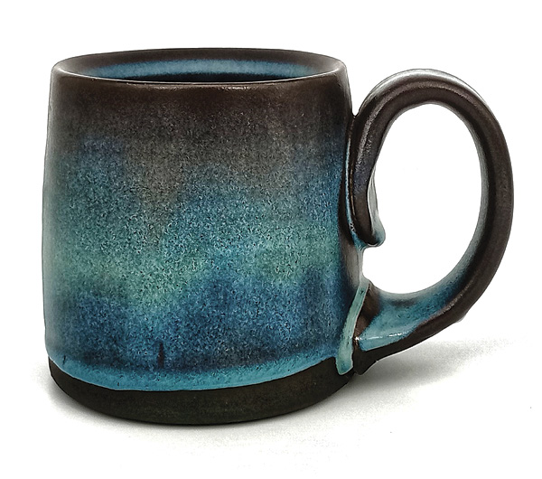 1 A mug made of Standard 213 porcelain/stoneware, with a veneer of Robin Hopper Dark Clay Slip, glazed with Coppage Satin Blue Rutile.
