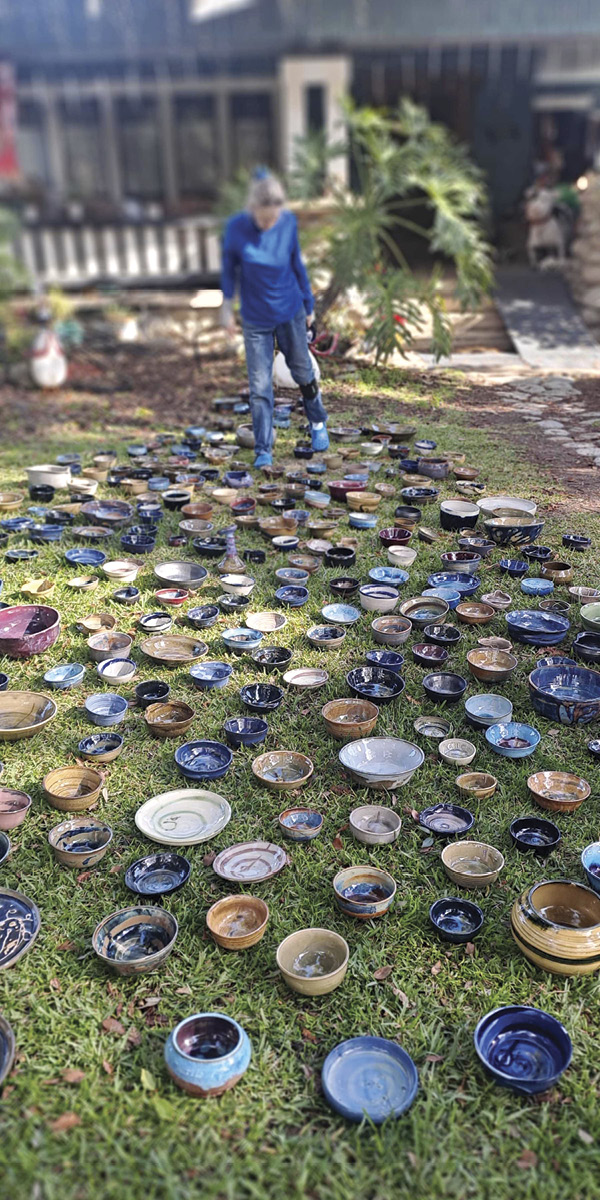 3 Artist Cynthia Lake inspects the Eaton Up^ 1.7.25 bowls that were distributed to fire survivors on the first anniversary of the fire.