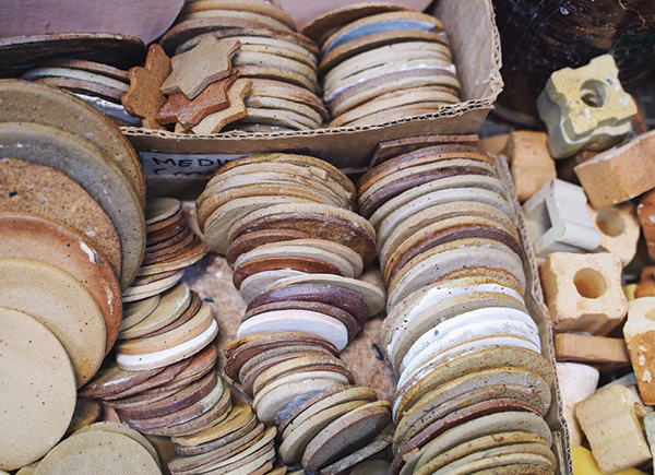 3 All sizes of kiln furniture and “cookies,” which are placed beneath glazed pieces in the kiln, are horizontally stacked for reuse.