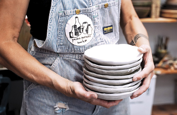 8 Angela Smith Kirkman with a set of handbuilt plates made with wild-harvested clay, which will be finished in a five-day anagama wood firing.