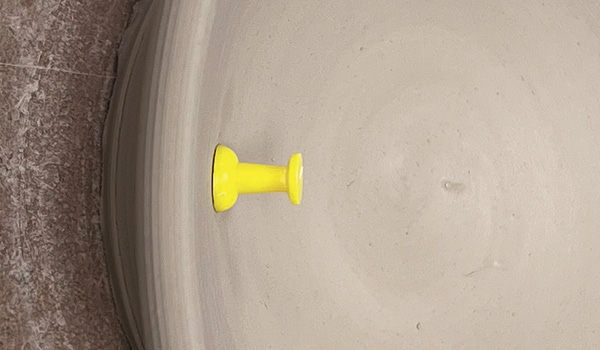 2 Insert the thumbtack into the interior wall of the bowl at the area to be trimmed