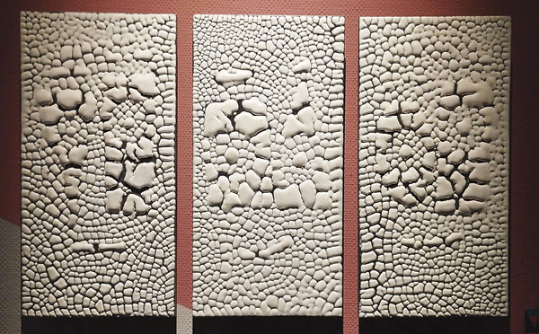 1 Test tiles showing the crawling glaze after firing to 900°C (Cone 08), with glaze islands exposing the dark clay body beneath.