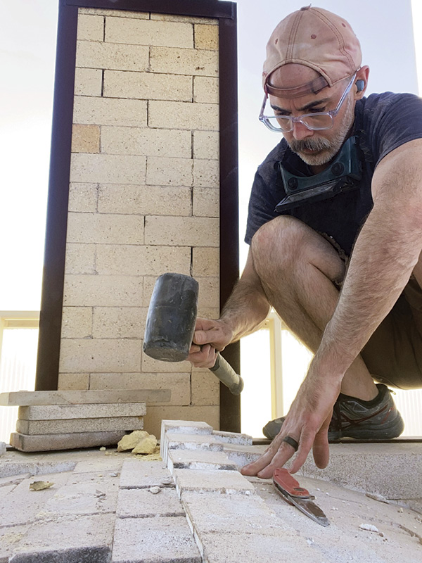 5 Tapping the center three rows of the arch from on top of the kiln.