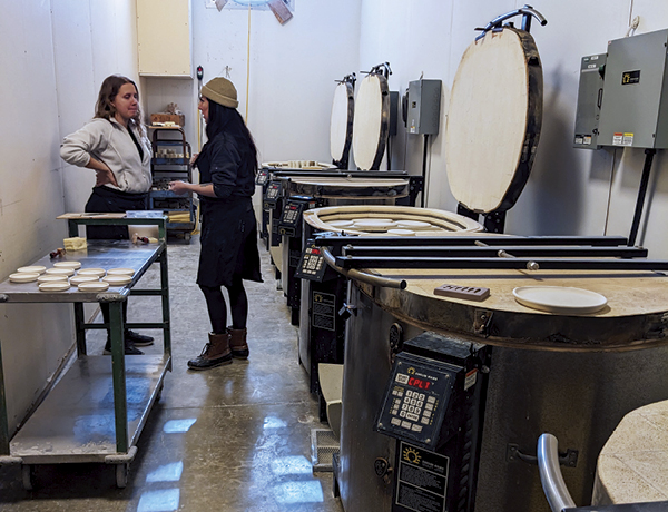 7 Two employees holding a discussion in the kiln room.