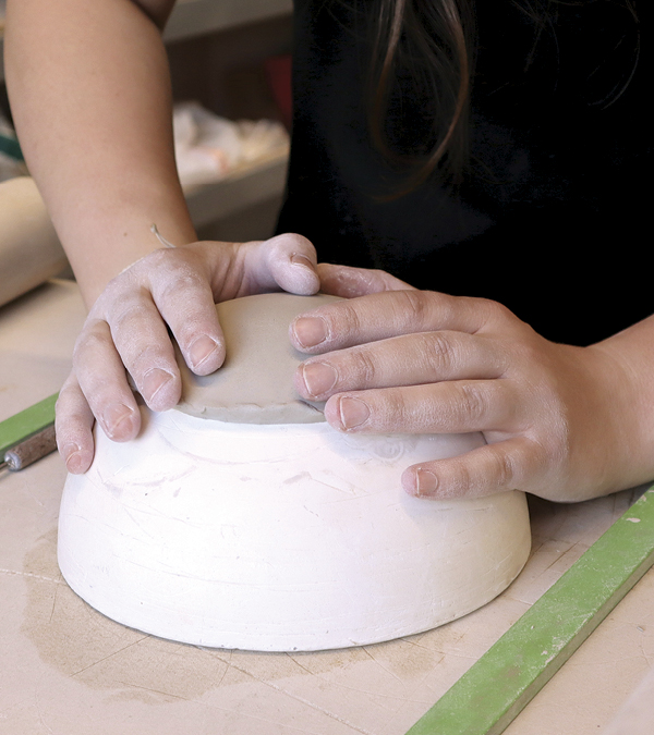 6 Press the center circle onto a hump mold. Smooth and compress it with a rubber rib.