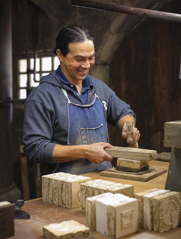 12 Jesse Pham, studio production manager at the Tileworks of Bucks County, presses a clay slab into a tile mold. Photo: Bridge Street Creative.