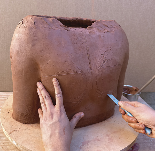 6 Cut a semicircle beneath each breast and push the clay from the inside to create volume. Fill the incision with a coil and refine the form.