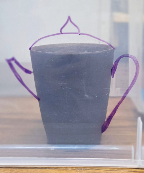 2 Using a dry-erase marker, draw onto the clear bin, sketching out ideas such as spouts.