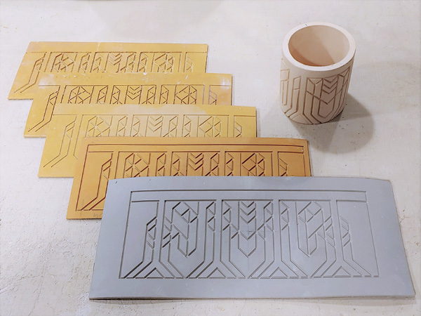 1 Hand-carved roller stamp and early versions of the darted mug texture mat leading to final version.
