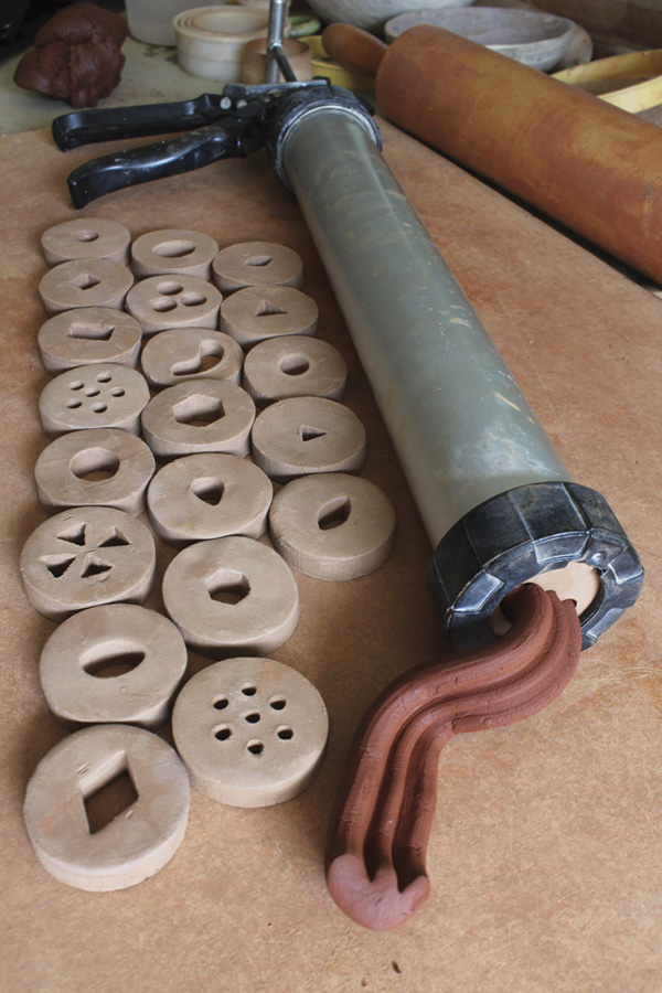 9 Once the dies have been fired, they are ready to use. To use with the extruder shown here (a Scott Creek Pottery Super Duper Clay Gun), first, unscrew the handheld extruder cap, fill the cylinder with a thick coil of clay, place the die into the