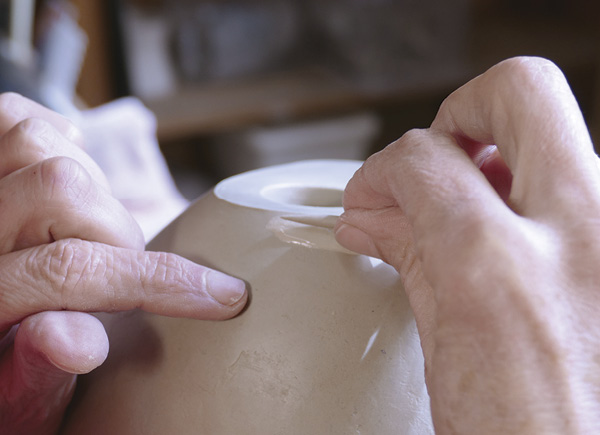 20 With some slip, apply the rolled grains onto the surface of the vase form.