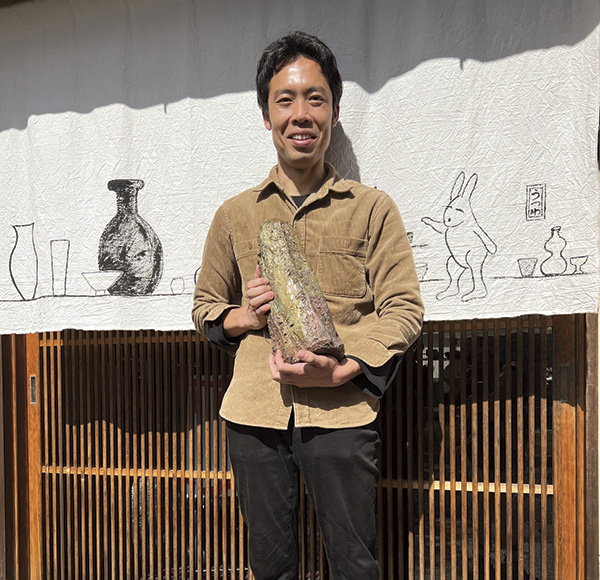 7 Tamba potter Ichino Shusaku with recent vase at the gallery entrance; noren (curtain) by artist Kawai Atsuko, commissioned by Yellin.