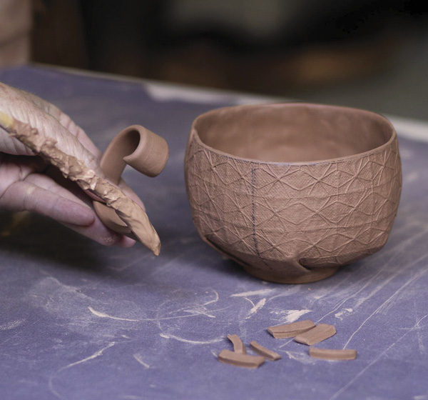 21 Brush slip onto the beveled edge and score the attachment points on the handle.