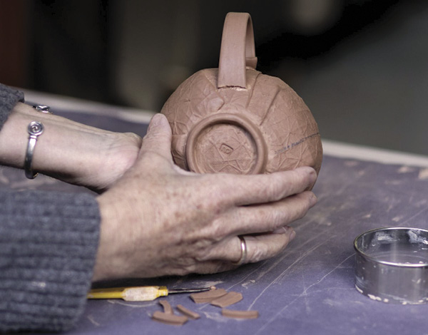 23 Add a small coil to the area where the bottom of the handle meets the cup to strengthen the connection.