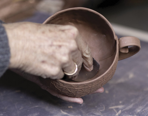 24 Use a flexible metal rib to scrape the interior to create a smooth, curved surface.