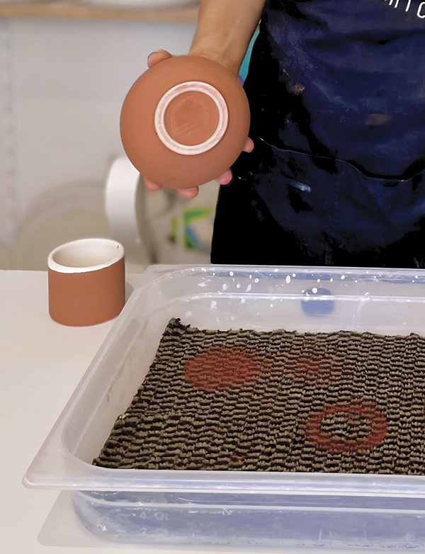 2 The damp carpet removes the glaze from the foot quickly and evenly, leaving a clean, glaze-free base ready for firing.