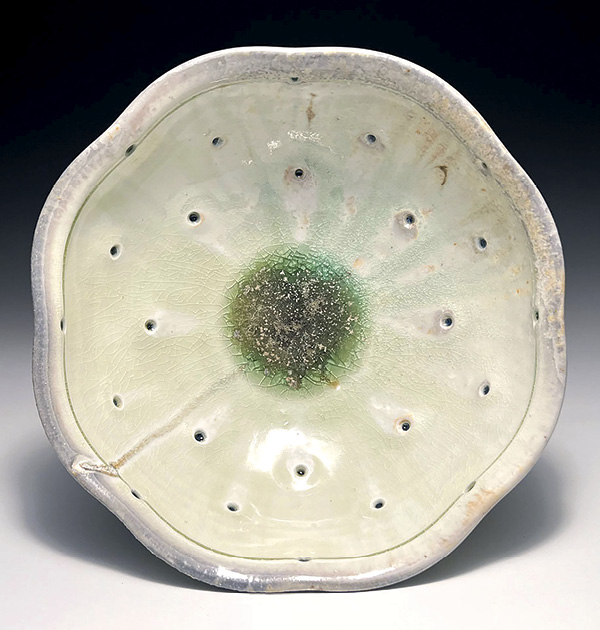 18 Andrew McIntyre’s perforated bowl, 11 in. (28 cm) in diameter, porcelain, glaze inlayed into perforations, wood fired to cone 11, 2023.