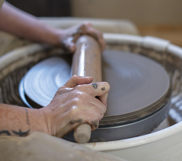 2 Push the clay down while holding the rolling pin stationary.