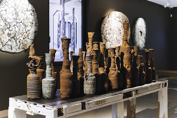 1 Pekka Paikkari’s The Last Feast!, 8 ft. 4 in. (2.5 m) in length, installation of 40 ceramic bottles dated 79 CE (foreground) and wall plates (background).