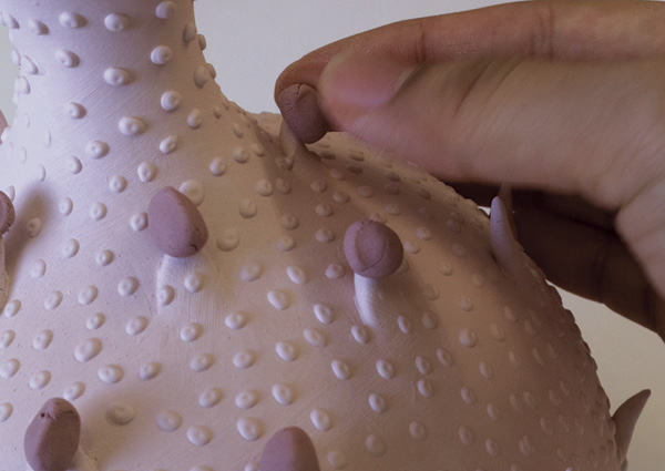 20 Placing gloop glaze on the tip of the bisqued vessel’s spikes.