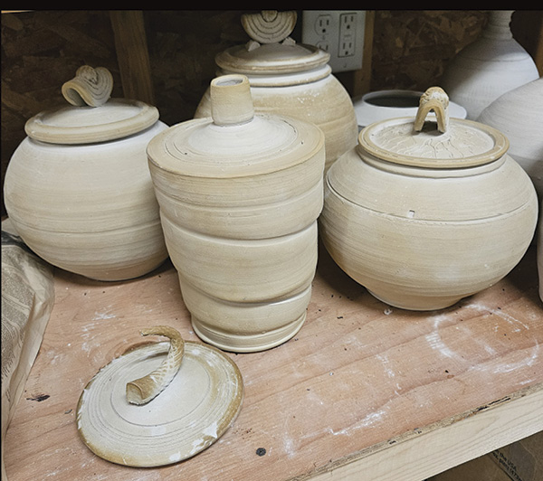 2 Dark discoloration on the edges of bone-dry stoneware jars from soluble salt migration.