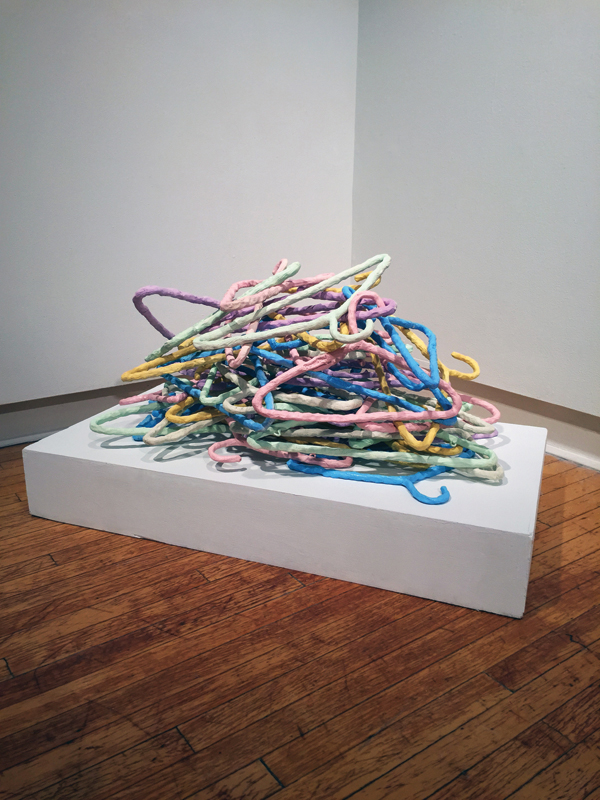 Ashley Bevington’s I’ll Get Around To It: Hanger Pile, 38 in. (97 cm) in length, clay, room-temperature glaze, 2015.