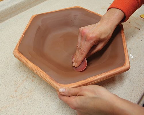 5 Use a rib to compress the clay, and to even out the surface.