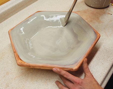 7 Add a layer of slip to the interior surface while the bowl is still in the mold. Repeat this, adding a total of three layers of slip.